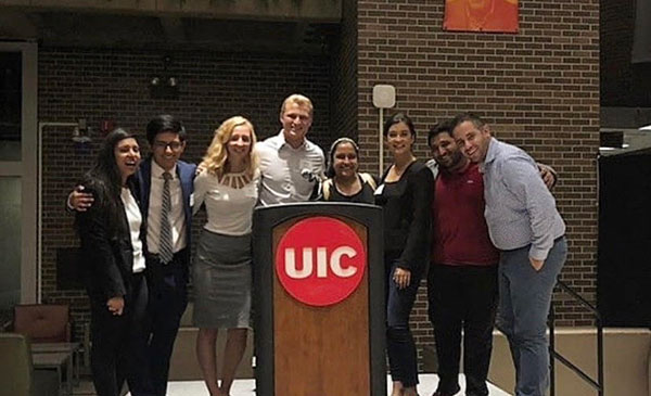 BSAB members standing aroudn a podium with the UIC logo on it.