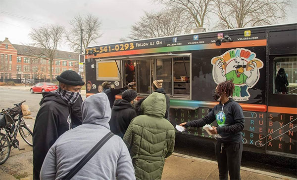People lined up outside a food truck during Earth's Remedies West Side Holiday Drive