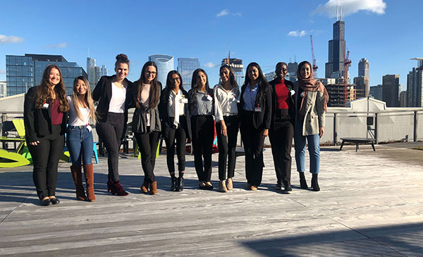 Members of the Undergraduate Women’s Network on the rooftop of the Google Chicago office with the Chicago skyline in the background.