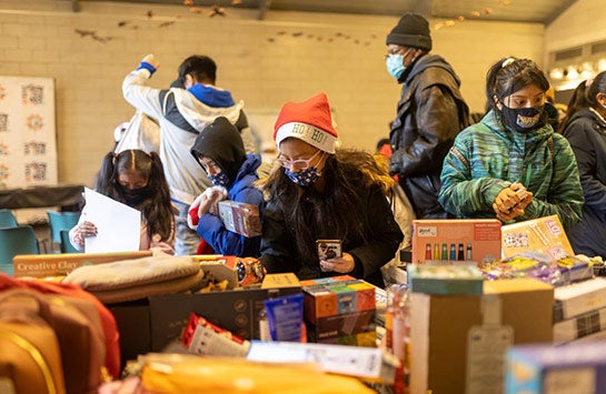 Community members selecting gifts at the Earth's Remedies Holiday for the West Side event