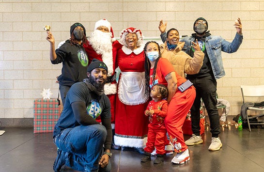 The Earth's Remedies team and community members smiling at the Holiday for the West Side event