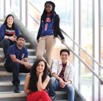 Students sitting and standing on staircase in ARC wearing UIC gear 