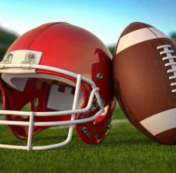 A red football helmet next to a football 
