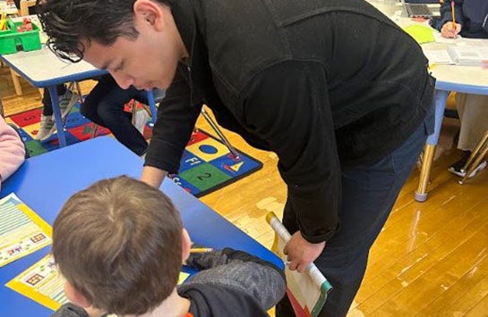 A UIC Business student teaching elementary school children as part of a Junior Achievement of Chicago volunteer service project