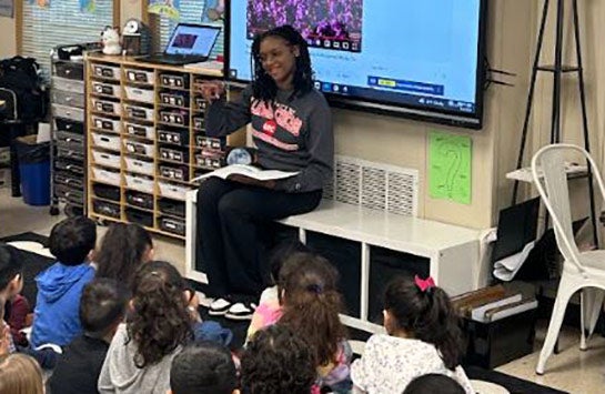 A UIC Business student teaching elementary school children as part of a Junior Achievement of Chicago volunteer service project